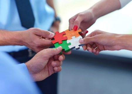 Group of business people assembling jigsaw puzzle