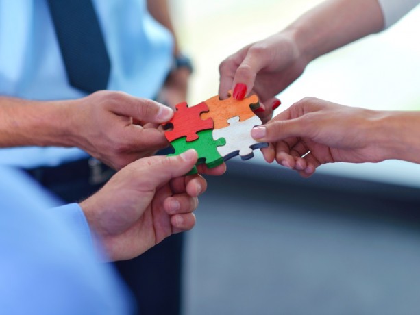 Group of business people assembling jigsaw puzzle